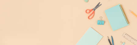 Top view of different stationery on a beige background. Back to school banner with copy space.