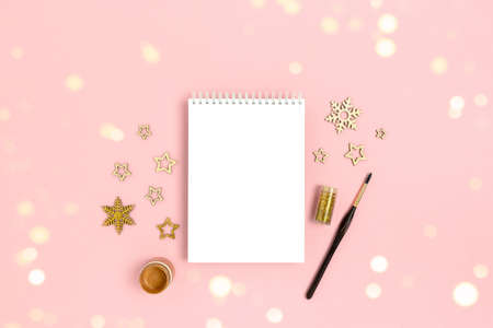 Blank notebook mockup with wooden New Years decoration, golden paint and glitter.