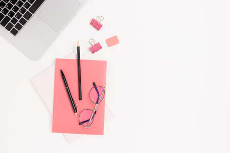 Workspace concept with laptop, glasses and pink office supplies. White table with place for text.の写真素材