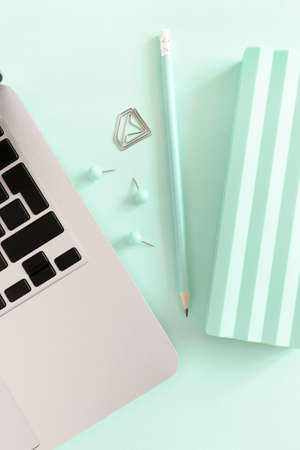 Composition with laptop and stationery on the mint table