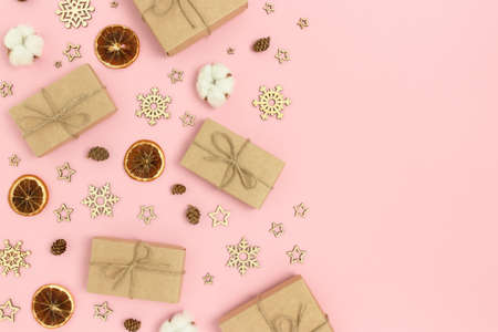 Frame made of natural Christmas decorations and gift boxes on a pink background. Festive composition with place for text.の写真素材