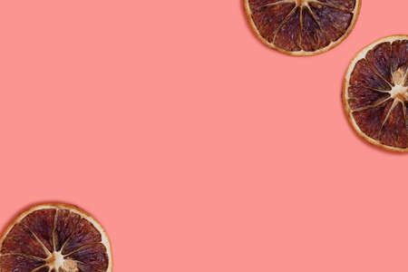Dried orange slices pattern on a coral background. Composition with copy space.の写真素材