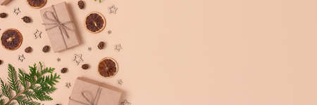 Banner with natural Christmas gifts, decorations and coniferous branches on a beige background. Zero...