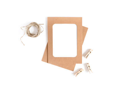 Styled minimal composition with kraft paper frame, wooden clothespins, twine on a white background