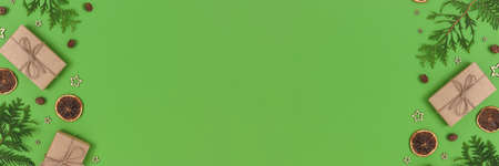 Banner with natural Christmas gifts, decorations and coniferous branches on a green background. Zero waste concept with copy space.の写真素材