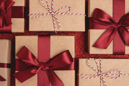Wrapped gifts on a red glittering background. Closeup festive composition.