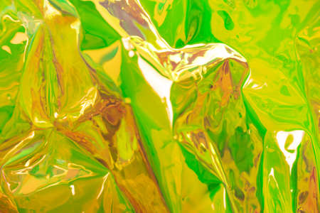Yellow blurred holographic background. Wrinkled foil texture. Abstract surreal backdrop with soft focus.の写真素材