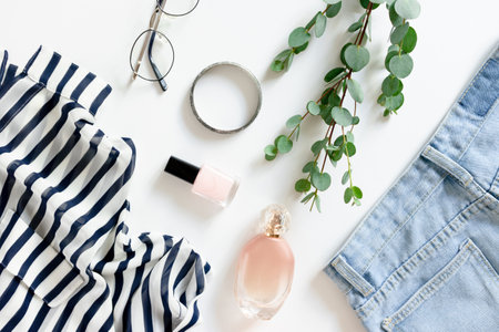Composition with eucalyptus branches, women summer clothes, cosmetics, accessories on a white...