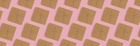 Banner wiht gift boxes pattern on a pink pastel background. Holidays composition.