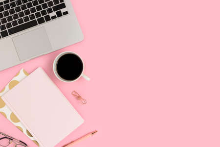 Workspace with coffee, office supply and laptop on a pink background. Homeschooling, e-learning, distance work concept with copy space.の写真素材