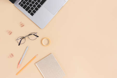 Top view of laptop, glasses and stationery on a beige background. Online education concept with copy space.の写真素材