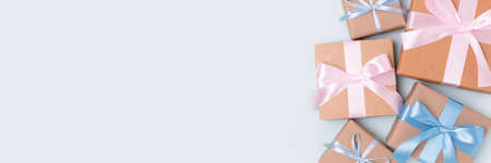 Banner with group of gift boxes on a blue pastel background. Present tied ribbon. Festive concept...