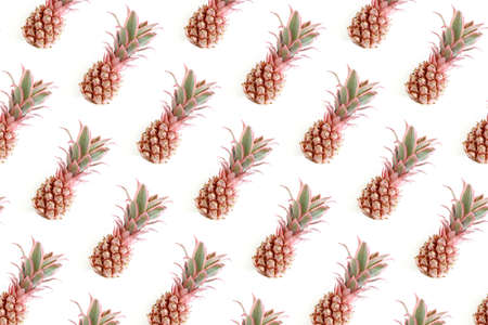 Trendy repetitive pattern made of pink pineapples. Summertime concept on a white background.