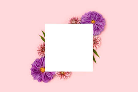 Paper card mockup with border frame made of dahlia flowers on a pink pastel background. Floral creative layout with copyspace.の写真素材