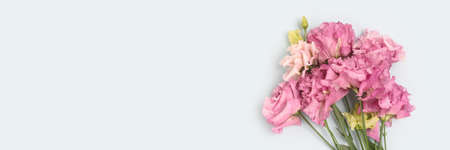 Banner with bouquet of eustoma flowers on a blue pastel background. Gift for Mothers Day.