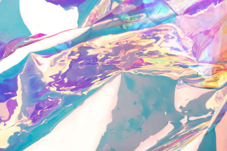 Defocused iridescent holographic background. Blurred colorful texture of wrinkled foil.の写真素材