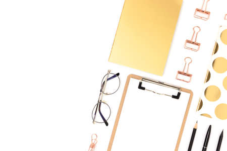 Layout of gold colored office stationery on a white background. Neat workspace with place for text.
