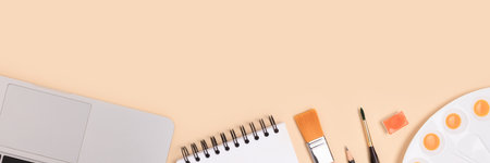 Banner with tools for painting on a beige background. Laptop, watercolor palette, paintbrush and stationery.の写真素材