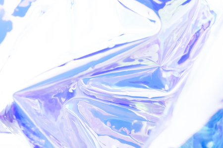 Blurred monochrome holographic background. Defocused texture of wrinkled foil in purple colors.