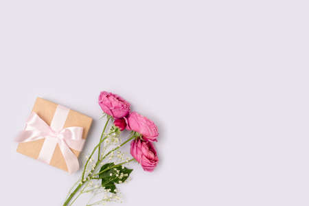 Present with a tied ribbon and bouquet of flowers on a blue background. Gift for Mothers Day with copyspace.の写真素材