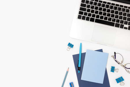 Laptop and blue office supplies on a white background. Workspace for homeschooling.