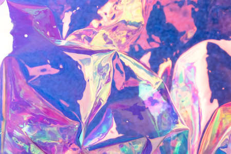 Defocused iridescent holographic background. Blurred colorful texture of wrinkled foil.の写真素材