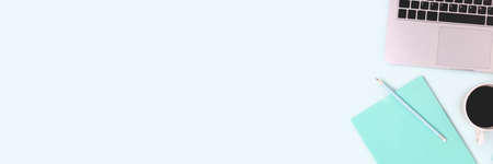 Banner with laptop, coffee and stationery on a blue background. Remote work, distance education concept with copy space.の写真素材