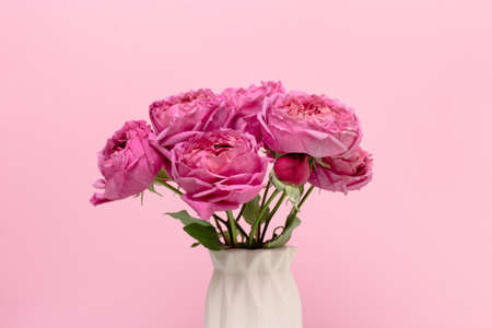 Minimalistic floral composition with bouquet of rose flowers in front of pink background. Gift for Mothers Day.の写真素材