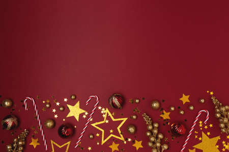 Frame made from Christmas toys and decorations on a red background.