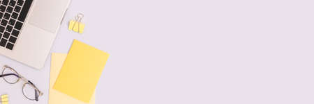 Banner with stationery, glasses and laptop on a blue background. Workspace for e-learning.の写真素材