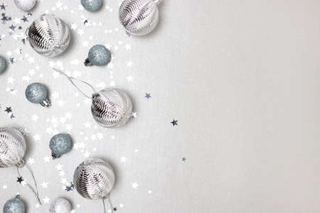 Frame made from silver colored Christmas baubles and confetti. Monochrome festive concept.の写真素材
