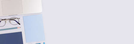 Banner with office supplies and laptop on a blue pastel background. Neat workspace for distance education.の写真素材