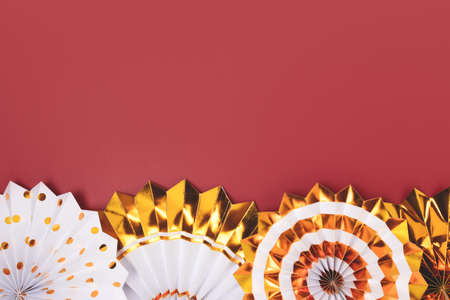 Row of golden paper fans on a red background. Festive composition with place for text.の写真素材