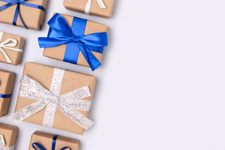Gifts tied with ribbons on a blue background. Festive creative layout with copy space.の写真素材