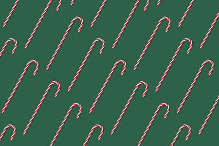 Repetitive pattern made of candy canes on a green background.の写真素材