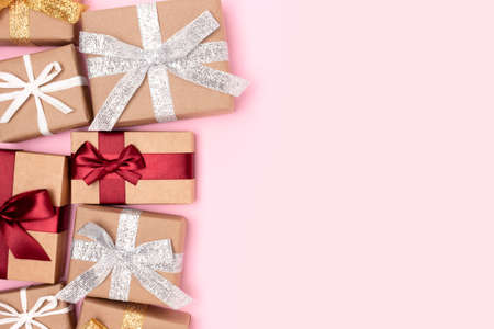 Wrapped gifts tied with ribbons on a pink background. Festive concept with place for text.の写真素材