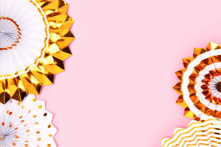 Border frame made of gold colored paper fans on a pink background.の写真素材