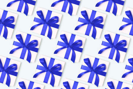 Repetitive pattern made from gift boxes with blue ribbons. Creative festive concept.の写真素材