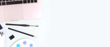 Banner with tools for painting on a blue background. Laptop, watercolor, paintbrush and stationery.