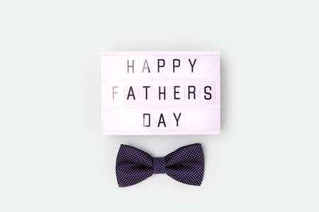 Happy Fathers Day - quote. Bow tie and lightbox on a blue pastel background.の写真素材