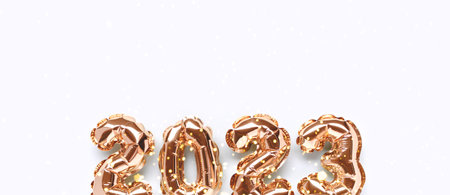 Banner with shiny 2023 gold inflatable balloons on a blue background with copy space. New Year's holiday concept.の写真素材