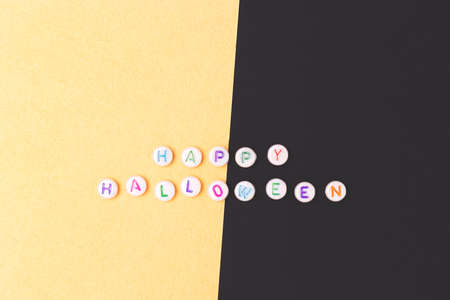 happy halloween. Quote made of white round beads with colorful letters on a gold and black...