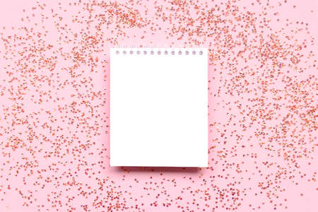 White clear notepad mockup with shiny crystals confetti on a pink background.