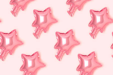 Repetitive pattern made from pink star foil balloon. creative layout.