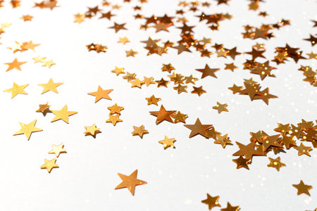 Glowing golden stars confetti scattered on a blue pastel background. selective focus.の写真素材