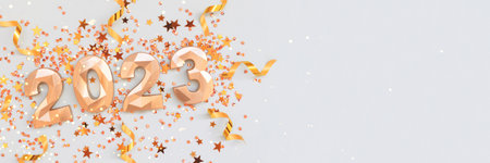Banner with 2023 golden numbers, ribbons and stars confetti on a blue pastel background. Festive concept with place for text.の写真素材