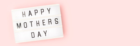 Happy Mothers Day - quote. Banner with white lightbox laying on a pink pastel background.の写真素材
