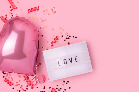 word love. Lightbox, confetti and inflatable foil balloon in a heart shape on a pink background. Place for text.の写真素材