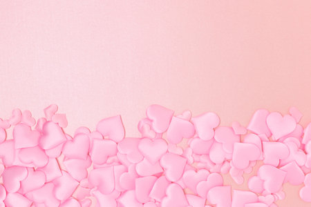Textile hearts confetti on a pink glittering background. copyspace. Monochrome concept.