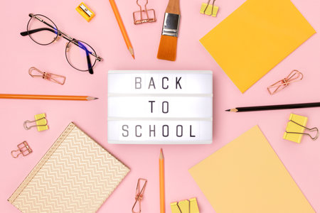 back to school. Lightbox with letters and frame made of stationery on a pink background.の写真素材